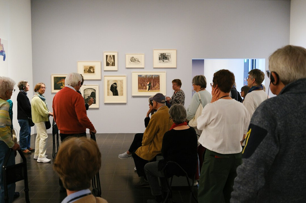 Visitors viewing framed photographs in a gallery exhibition
