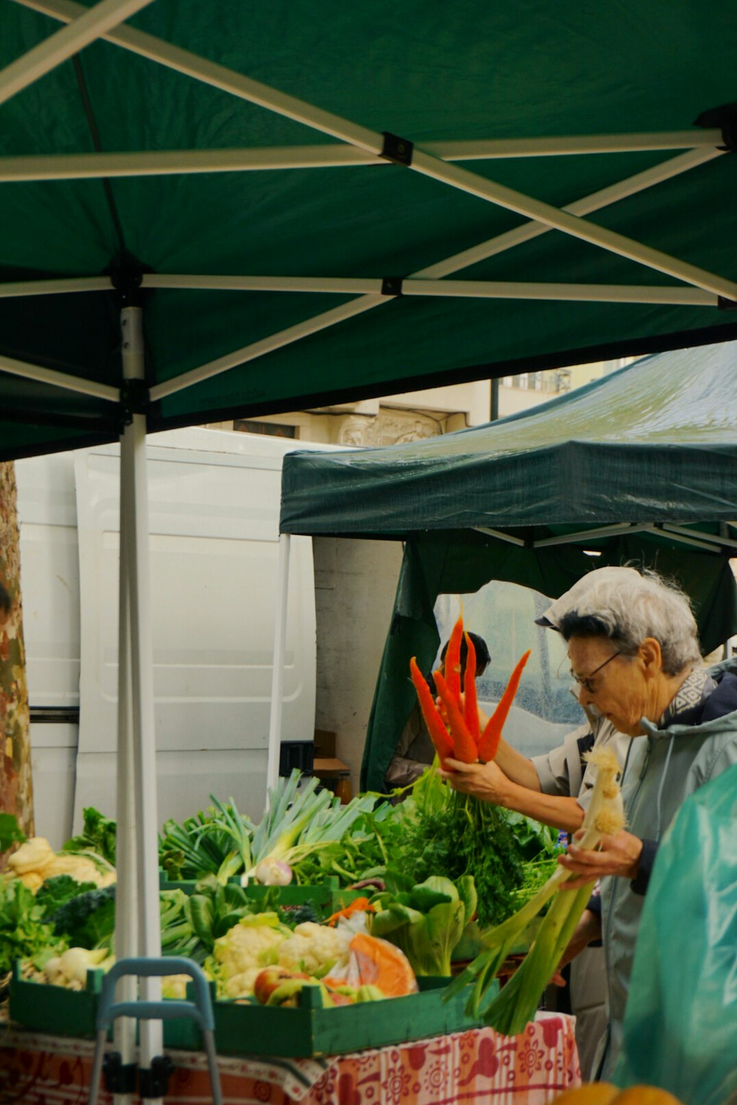 Market stall vendor arranging vegetables
